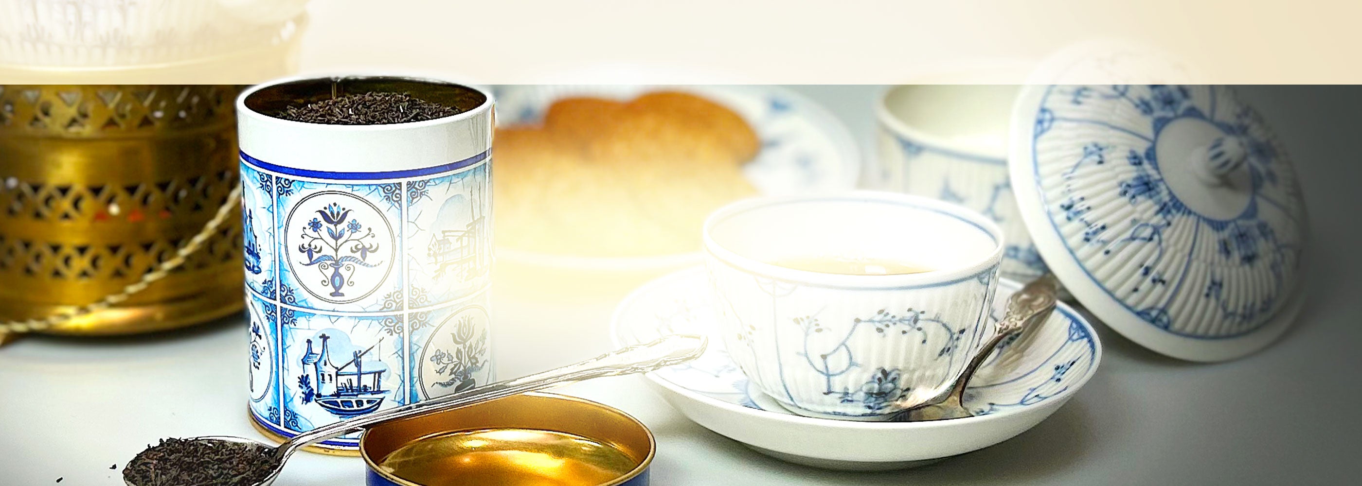 Ostfriesische Teetasse neben einer geöffneten Dose Schwarztee und einer Zuckerschale