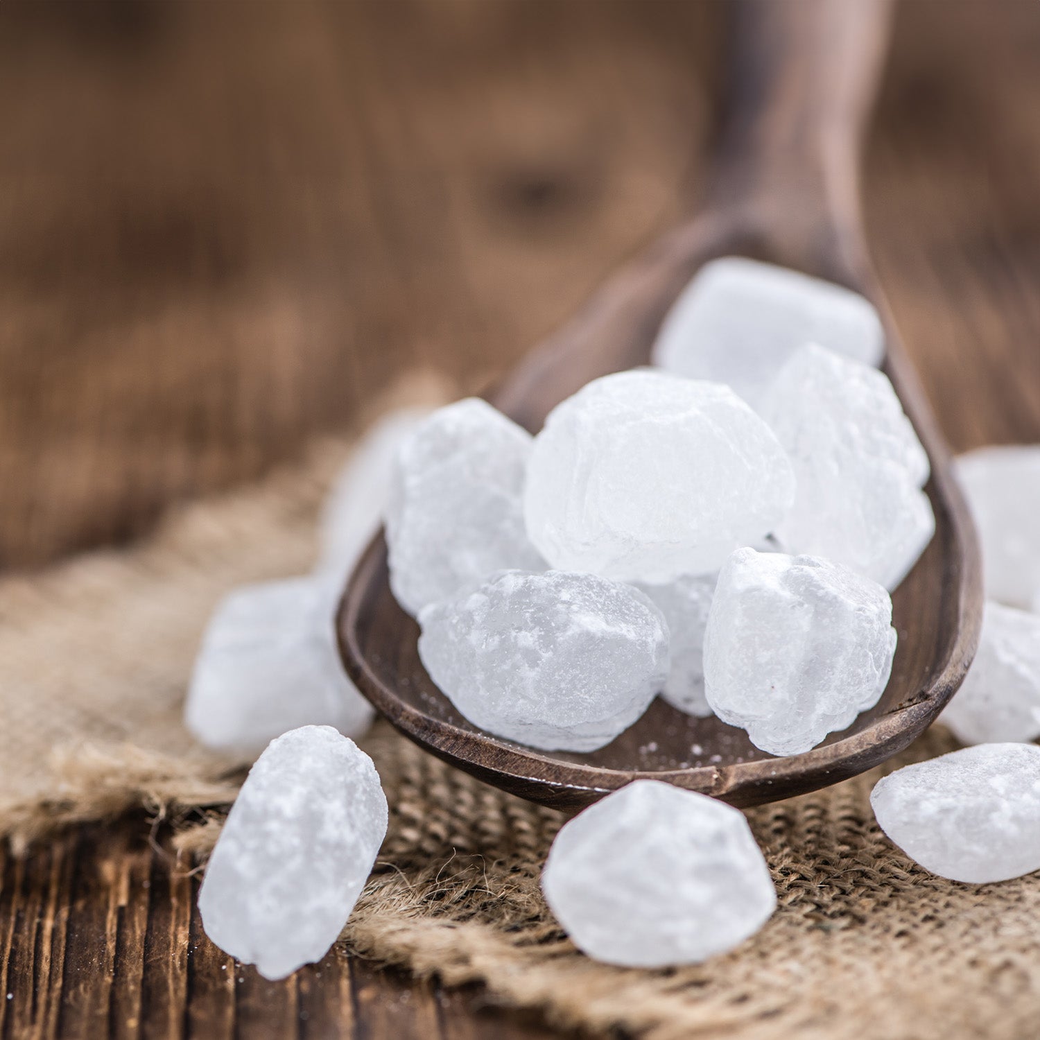 Ein Holzlöffel mit mehreren Würfeln weißem Kandiszucker
